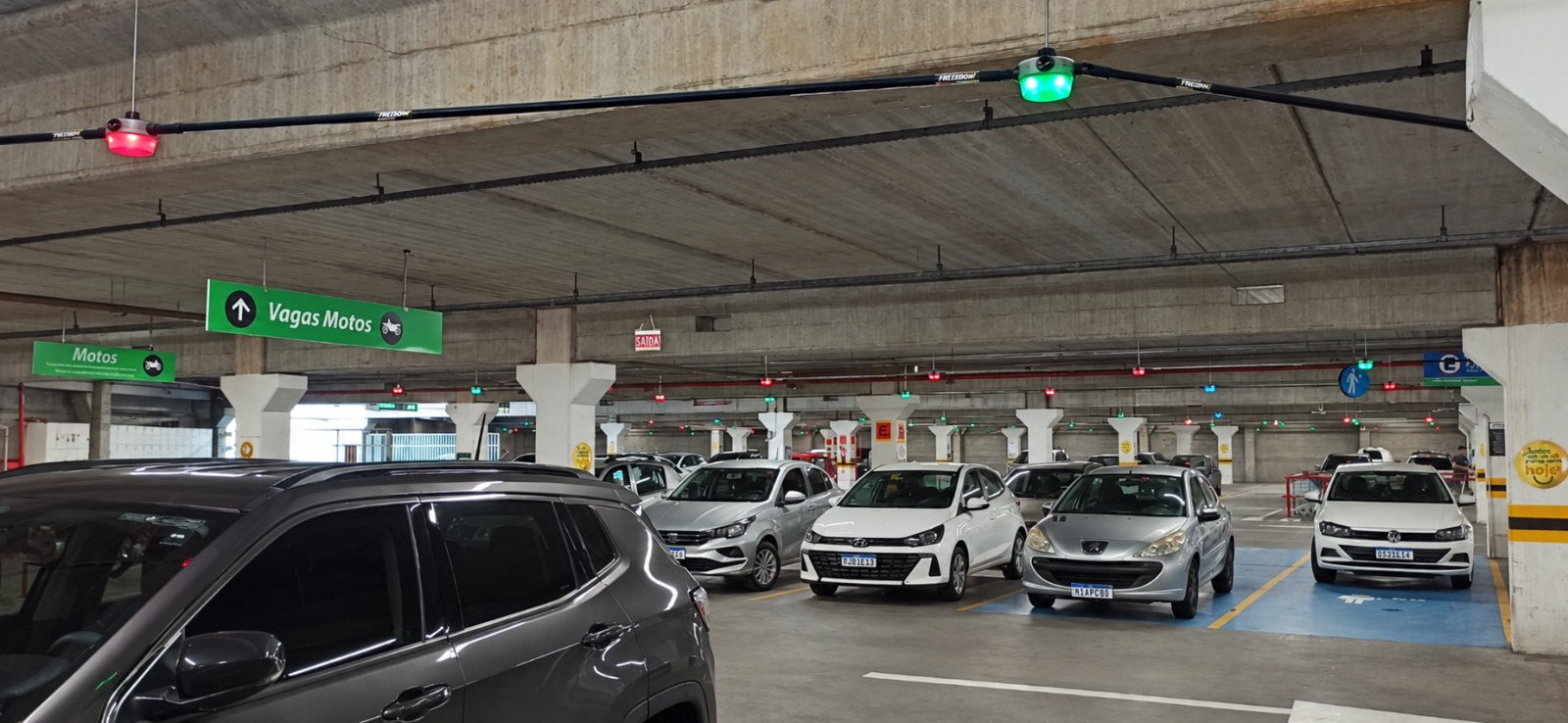 Sensores verdes e vermelhos sobre as vagas de um estacionamento em operação